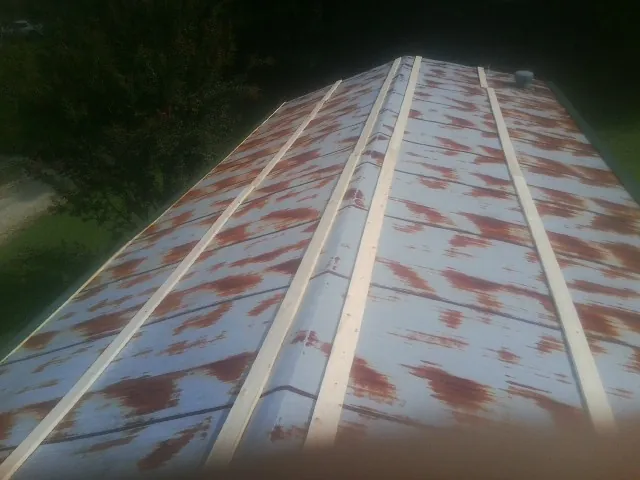 Rusted metal roof panels with new wood purlins before replacement — Storm Damage Roof Repair in Lyons by Roofing Brothers